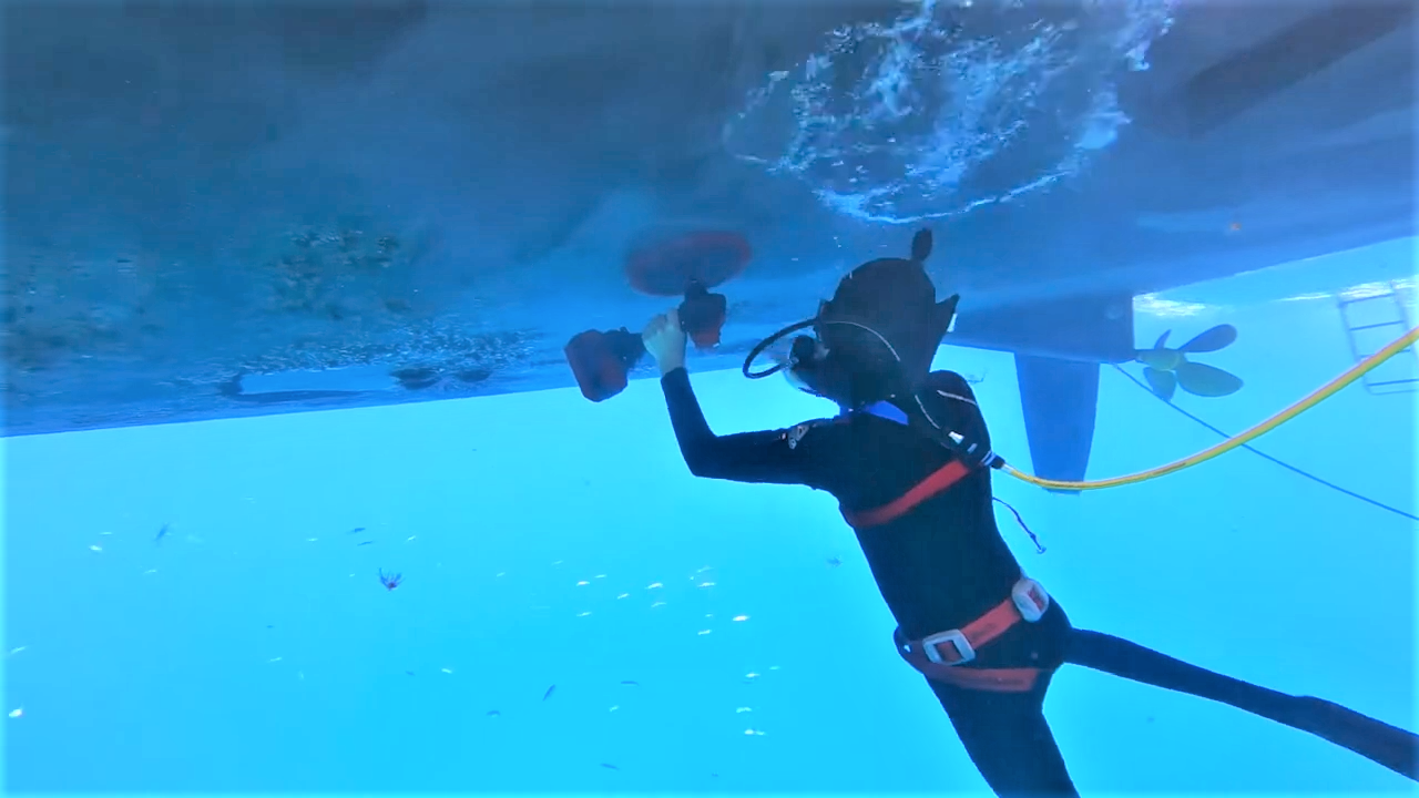Picture of a Hookah diver breathing via a hookah air hose while cleaning underneath a boat hull and propeller.
